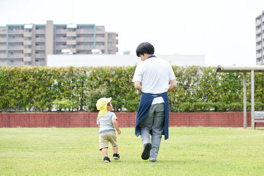 芝生で遊ぶ子供と男性の保育士