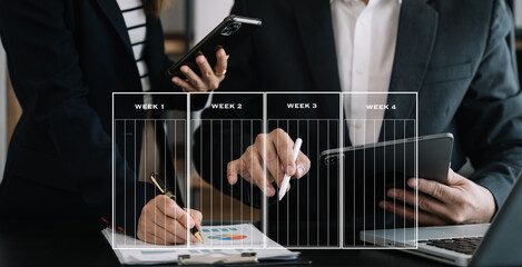 Business team hand Project manager working and update tasks and Gantt chart scheduling virtual diagram.with smart phone, tablet and laptop in office.