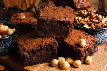 Board with tasty chocolate brownie on table, closeup