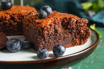 Plate with pieces of tasty chocolate brownie on table, closeup