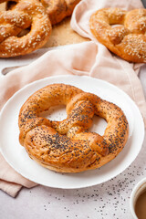 Plate with tasty pretzel on light table, closeup