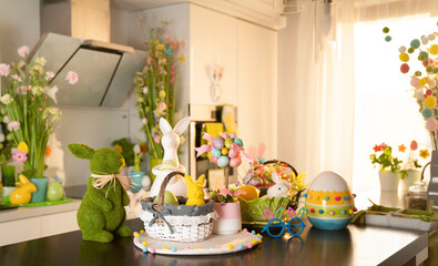 Easter theme. Easter decorations. Easter eggs in basket and easter bunny. Bouquet of spring flowers. Shining wooden brown table.
