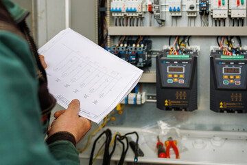 Close up hand of engineer or electrician man working check the electrical system with tablet at factory