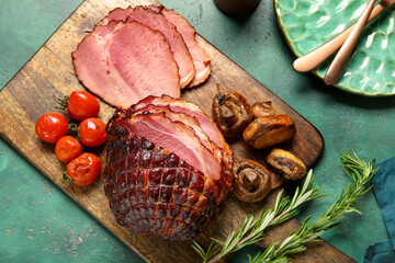 Wooden board with tasty smoked ham and grilled vegetables on green grunge background