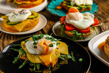 Plates with tasty eggs Benedict on wooden background