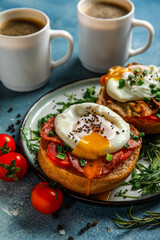 Plate with tasty eggs Benedict on blue background