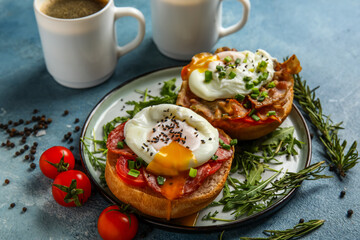 Plate with tasty eggs Benedict on blue background