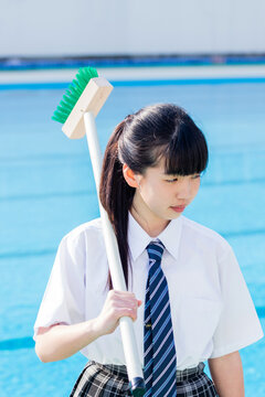 プール掃除をする女子中学生