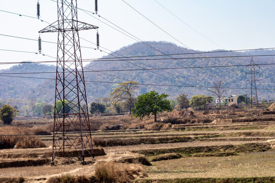 Electrical Pole installation in the fields of Chota Nagpur Plateau against mountain in the background. Ramgarh Jharkhand India