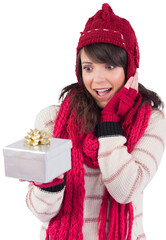 Surprised young woman holding a wrapped gift