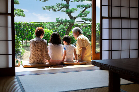 縁側に座る老夫婦と孫