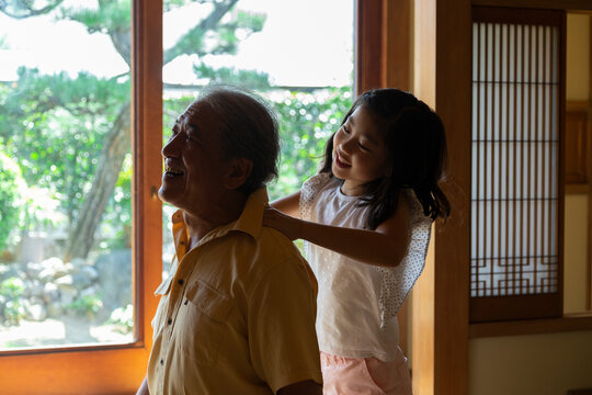 祖父の肩叩きをする孫