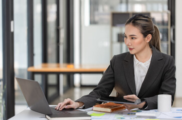 Fototapeta premium Happy excited young successful asian business woman working at the table in office, Businesswoman and finance marketing. 