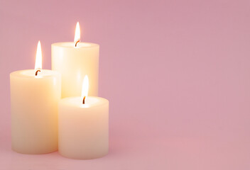 Obraz na płótnie Canvas Burning scented candles on pink background. Copy space for text.