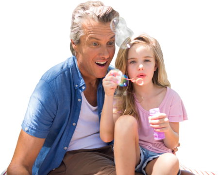 A little girl blowing bubbles with her father