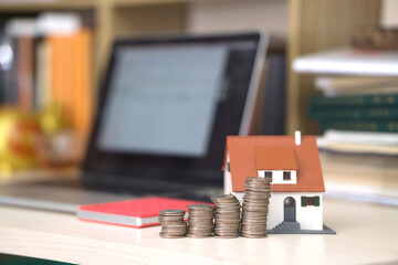A house model and incremental coins on the desk