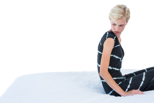 Doubtful blond woman sitting on bed