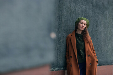 Portrait of a young woman over 30 years old in a beret and a stylish coat, a girl walks around the...