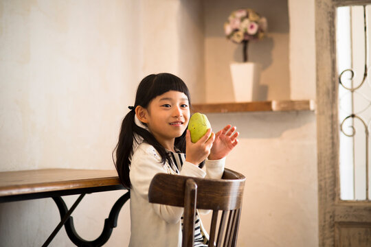 部屋で果物を持つ女の子