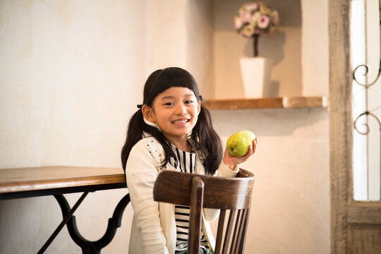 部屋で果物を持つ女の子