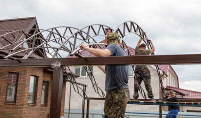 Naklejka premium The worker installs the metal on the canopy.
