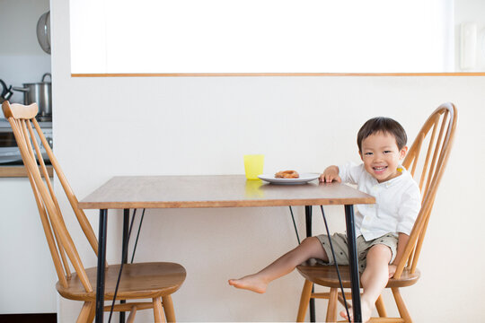 テーブルでおやつを食べる男の子