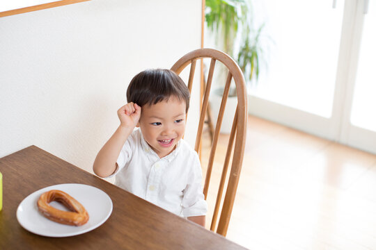 テーブルでおやつを食べる男の子