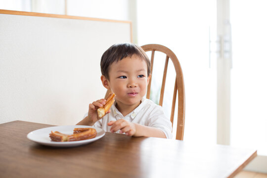 テーブルでおやつを食べる男の子