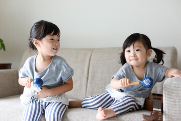 マラカスを持って遊ぶ小さな姉妹