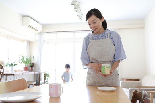 テーブルの上のカップを片付ける主婦