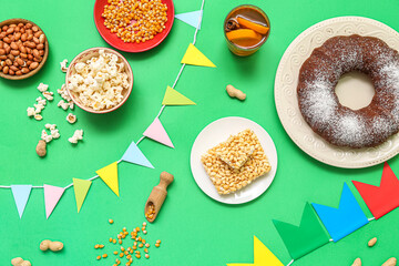 Traditional food with flags for Festa Junina (June Festival) on green background