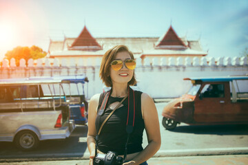 asian woman with dslr camera in hand standing infront of temple in ayutthaya world heritage site of unesco central of thailand