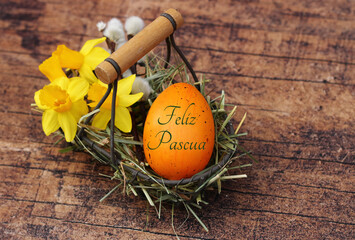 Feliz tarjeta de felicitación de Pascua. Cesta con narcisos y un huevo de Pascua inscrito.