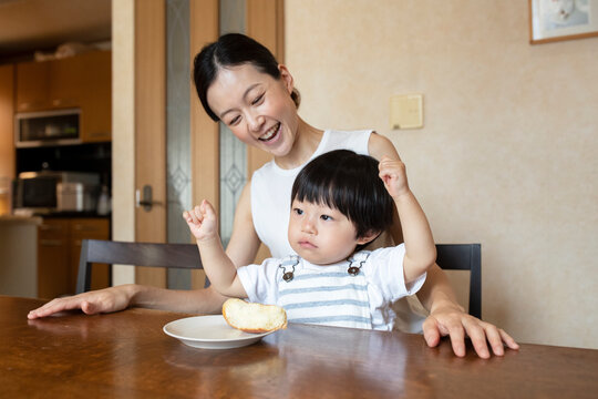 パンを食べる子どもと母親