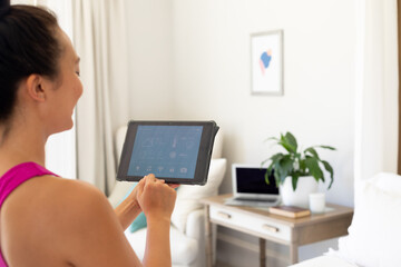 Happy asian woman using tablet with smart home interface