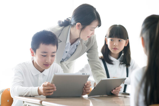 先生にプログラミングの勉強を教わる小学生  AR