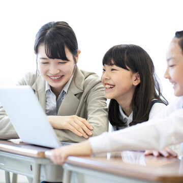 先生にプログラミングの勉強を教わる小学生  