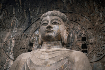 Fototapeta na wymiar Longmen Grottoes,statues of Buddha and Bodhisattvas carved with stair for tourist to travel in the mountain rock near Luoyang in Hennn province, China.Longmen major Buddhist caves and a World heritage