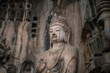 Fototapeta na wymiar Longmen Grottoes with Buddha's figures are Starting with the Northern Wei Dynasty in 493 AD. It is one of the four notable grottoes in China.