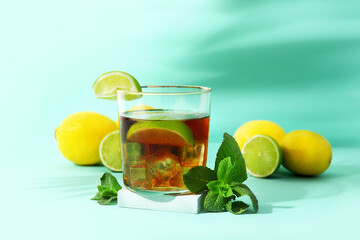 Glass of cold rum on turquoise background
