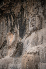 Fototapeta na wymiar The Longmen Grottoes or Longmen Caves are one of the finest examples of Chinese Buddhist art. Sitting Buddha