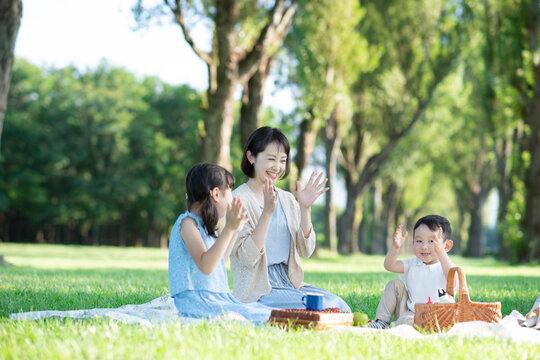 ポプラ並木でピクニックをする親子
