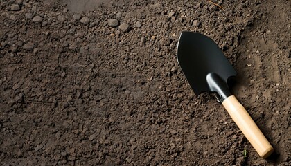 Dark earth with a black shovel / spade. Space for text. Ideal as background. © PixobaPICS