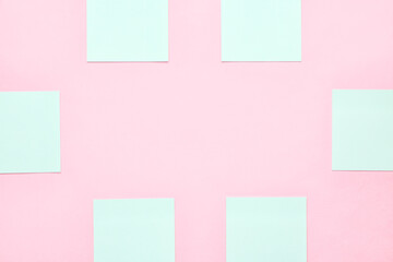 Frame made of blue sticky notes on pink background