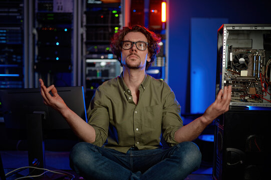 Pensive technician meditating in server room at modern data center - Powered by Adobe