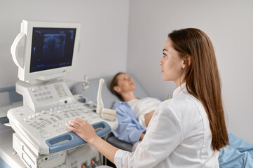 Obraz na płótnie Canvas Selective focus doctor doing ultrasound of fetus to pregnant woman