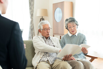 ビジネスマンと話をするシニア夫婦