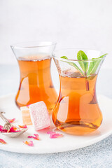Glasses of tea and Turkish delight on light background