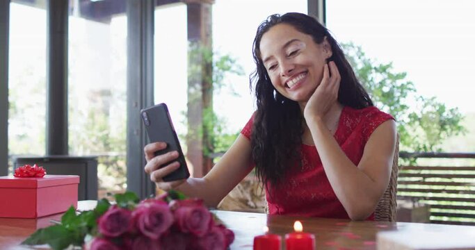 Happy biracial woman making valentine's day video call on tablet, sending kisses