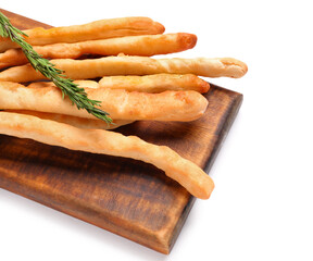Wooden board with tasty Italian Grissini on white background, closeup